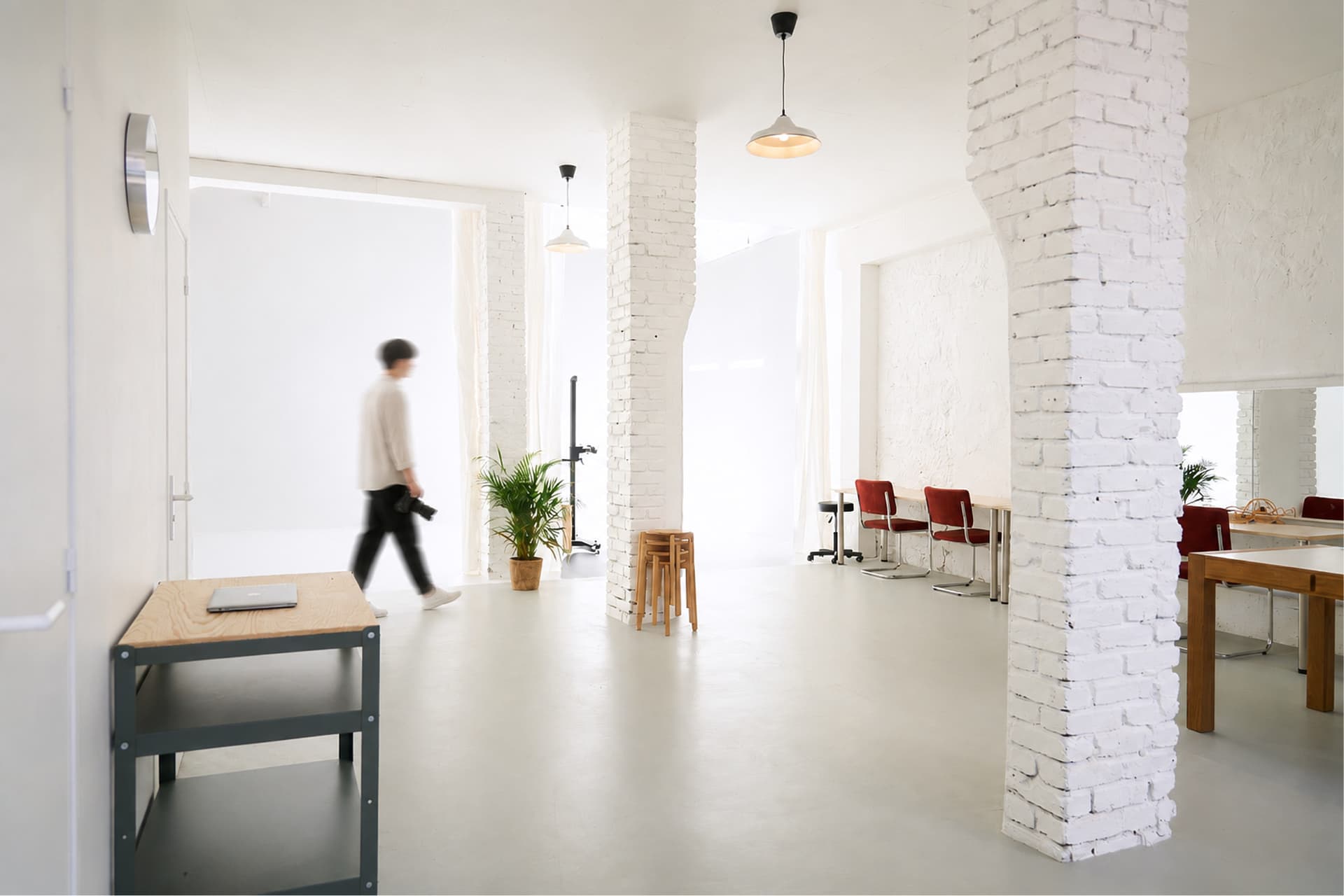 Espace du studio avec colonnes de brique blanche et coin bureau